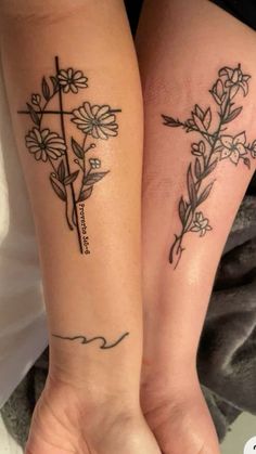 two people with matching tattoos on their arms, one has a cross and the other has flowers