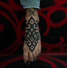 a woman's foot with an intricate tattoo design on her left foot and the word love written in black ink