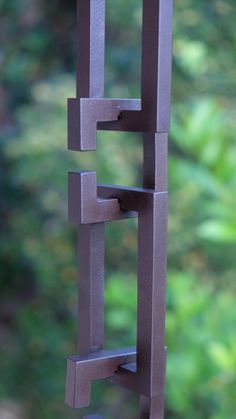 a close up of a metal object with trees in the background