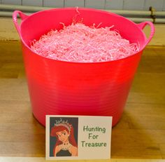 a pink tub filled with lots of pink stuff next to a sign that says hunting for treasures