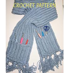 a knitted scarf with crochet needles and scissors on it