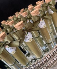 several champagne bottles with green ribbons tied around them and tags on the corks in front of them