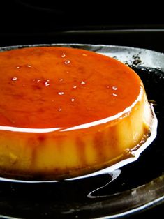 a cheesecake on a pan with sauce drizzled around it's edges