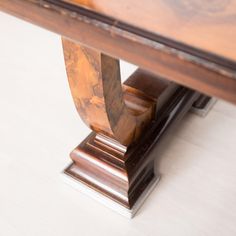 a close up view of a wooden table with metal base and wood grained edges