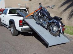 a motorcycle is being loaded onto the back of a truck