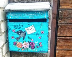 a blue mailbox with flowers painted on it