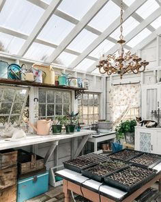 a kitchen with lots of pots and pans on the stove top in front of a chandelier