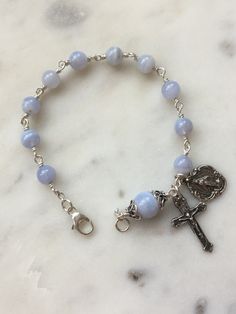 Beautiful handmade 6 and 8mm blue lace agate rosary bracelet. The beads are wire-wrapped with sterling silver, 22 gauge wire and all other metal parts and medals are sterling silver. Cheap Blue Rosary Bracelet As Gift, Blue Agate Jewelry, Blue Lace Agate Jewelry, Blue Lace Agate Bracelet, Blue Rosary, Jewelry Styles, Catholic Jewelry, Rosary Bracelet, Fantasy Story