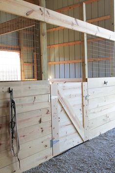 the inside of a horse barn with wooden stalls