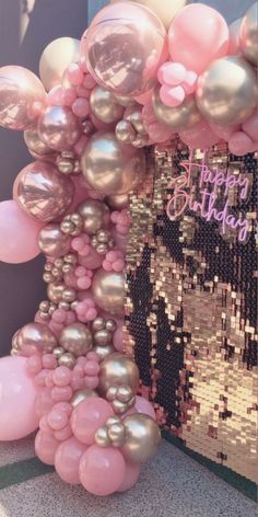 pink and silver balloon arch with happy birthday message on it in front of a sequin backdrop