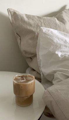 a cup of coffee sitting on top of a table next to a pillow and blanket