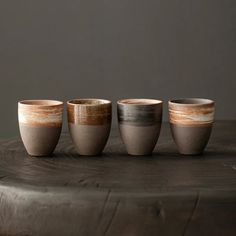 three cups sitting on top of a wooden table