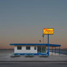 a fast food restaurant sitting on the side of a road next to an empty parking lot