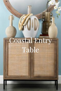 a table with vases and other items sitting on it's sideboard that says coastal entry table