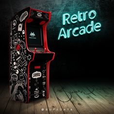 an arcade machine sitting on top of a wooden floor in front of a neon sign