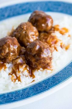 some meatballs and rice on a blue and white plate