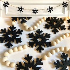 black and white snowflakes are hanging on the wall next to beaded necklaces