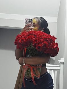 a woman taking a selfie with flowers in front of her face while holding a camera