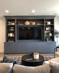 a living room filled with furniture and a flat screen tv on top of a wooden entertainment center