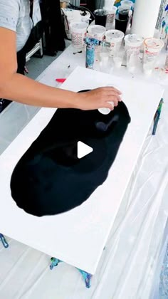 a woman is making an art project with black fabric