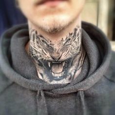 a man with a tiger tattoo on his neck is wearing a hoodie and looking at the camera