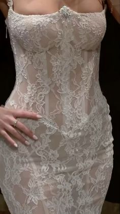 the woman is wearing a white dress with sheer lace