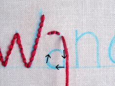 the word w is written in blue and red yarn with an arrow pointing to it