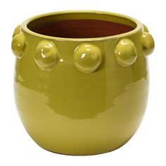 a yellow ceramic pot with three balls on the top and two holes in the middle