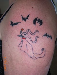 a person with a tattoo on their arm that has bats and a ghost in it