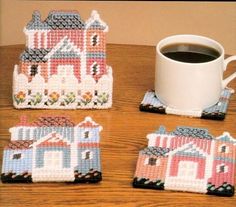 four coasters with houses on them and a cup of coffee