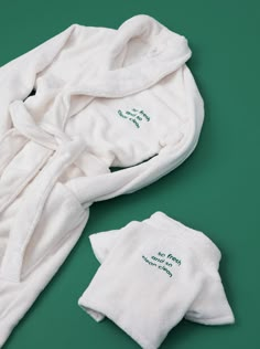 two white robes with embroidered words on them