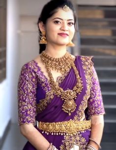 a woman in a purple and gold outfit standing next to stairs with her hands on her hips