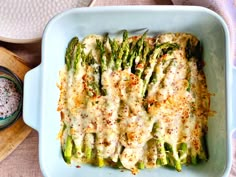 a casserole dish with asparagus and parmesan cheese on top