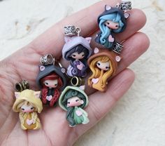 a hand is holding some little princesses charms