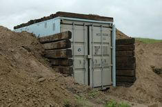 an outhouse sitting on top of a pile of dirt