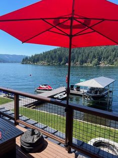 a deck with an umbrella and boats on the water