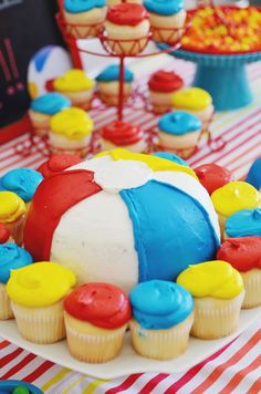 a table topped with lots of cupcakes covered in frosting and colorful icing