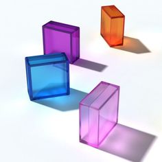 three different colored cubes sitting on top of each other in the middle of a white surface