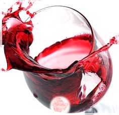 red wine being poured into a glass on a white background with splashing water around it