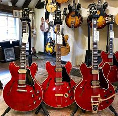 several guitars are lined up in a room