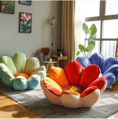 two colorful flower shaped chairs sitting on top of a rug in front of a window