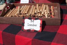 a wooden box filled with lots of cinnamons on top of a red and black checkered table cloth