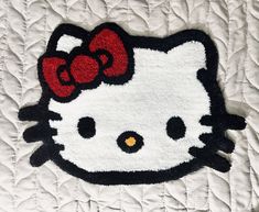 a hello kitty rug with a red bow on it's head is laying on a bed