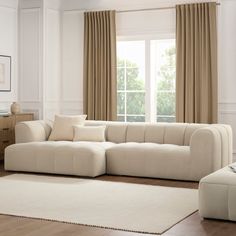 a large white couch sitting in front of a window