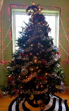 a decorated christmas tree in front of a window