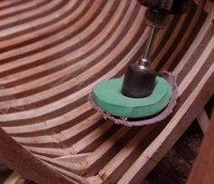 a green and black duster sitting on top of a wooden table next to a drill