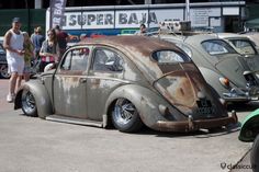 an old vw bug is parked on the street