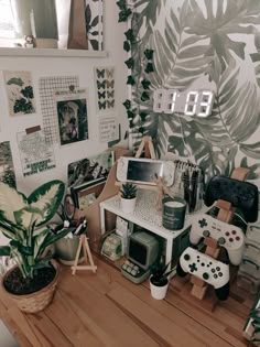 a wooden table topped with lots of clutter next to a wall covered in plants