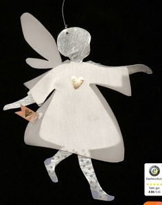 a white angel ornament hanging from a string on a black background with an orange tag in the shape of a heart