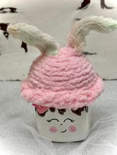 a cup with a pink hat on top of it